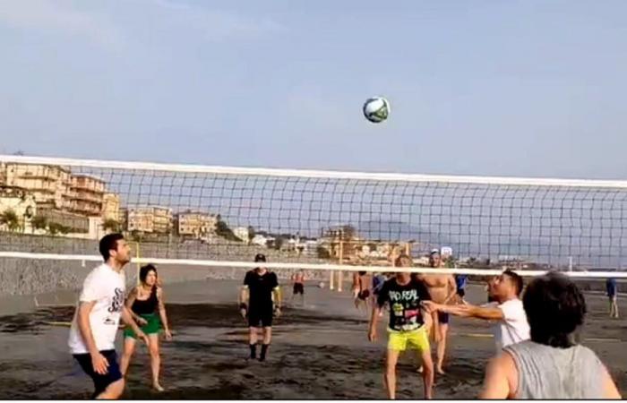 jugar al fútbol y al voleibol en un campo real en una playa de Portici”